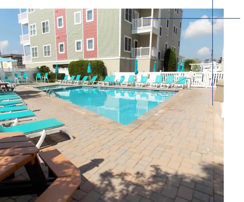 The Monarch Condominiums pool deck with teal lounge chairs
