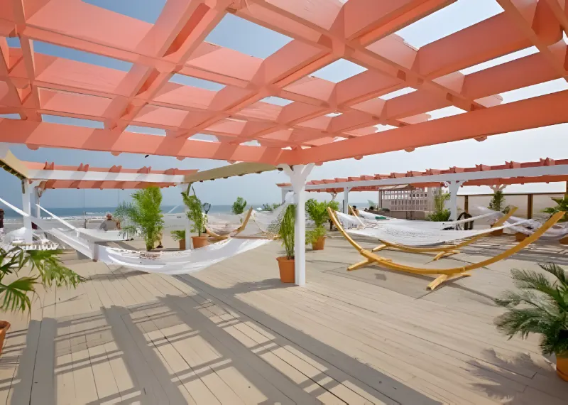 Hammocks under the coral pergola on the 5th Floor Cabana Hammock Sundeck, with the ocean beyond