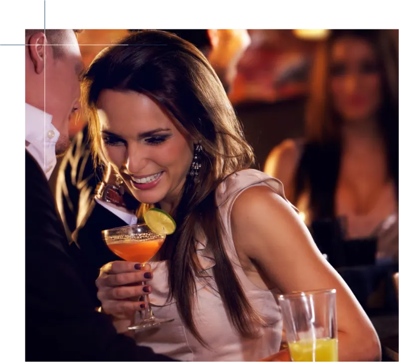 Woman enjoying a cocktail at a lively nightspot